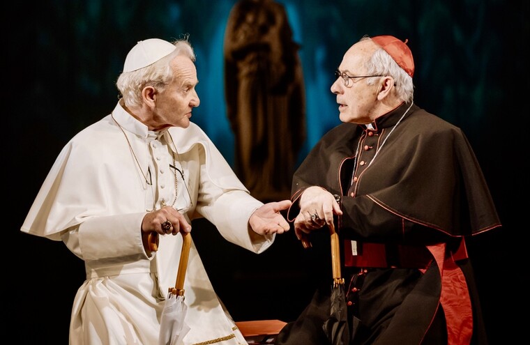 The Pope and Archbishop sit next to each other in conversation