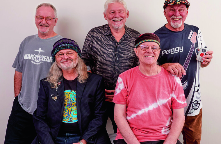 Members of Fairport Convention. Two men sit down, three other men stand behind.