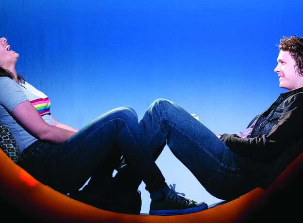 Two people sat on the floor, laughing together