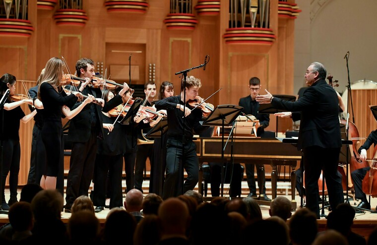 An orchestra performs on stage